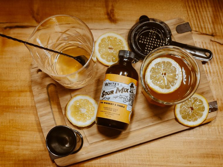White's Elixers Sour Mix Whiskey Sour in glass with mixing glass and spoon