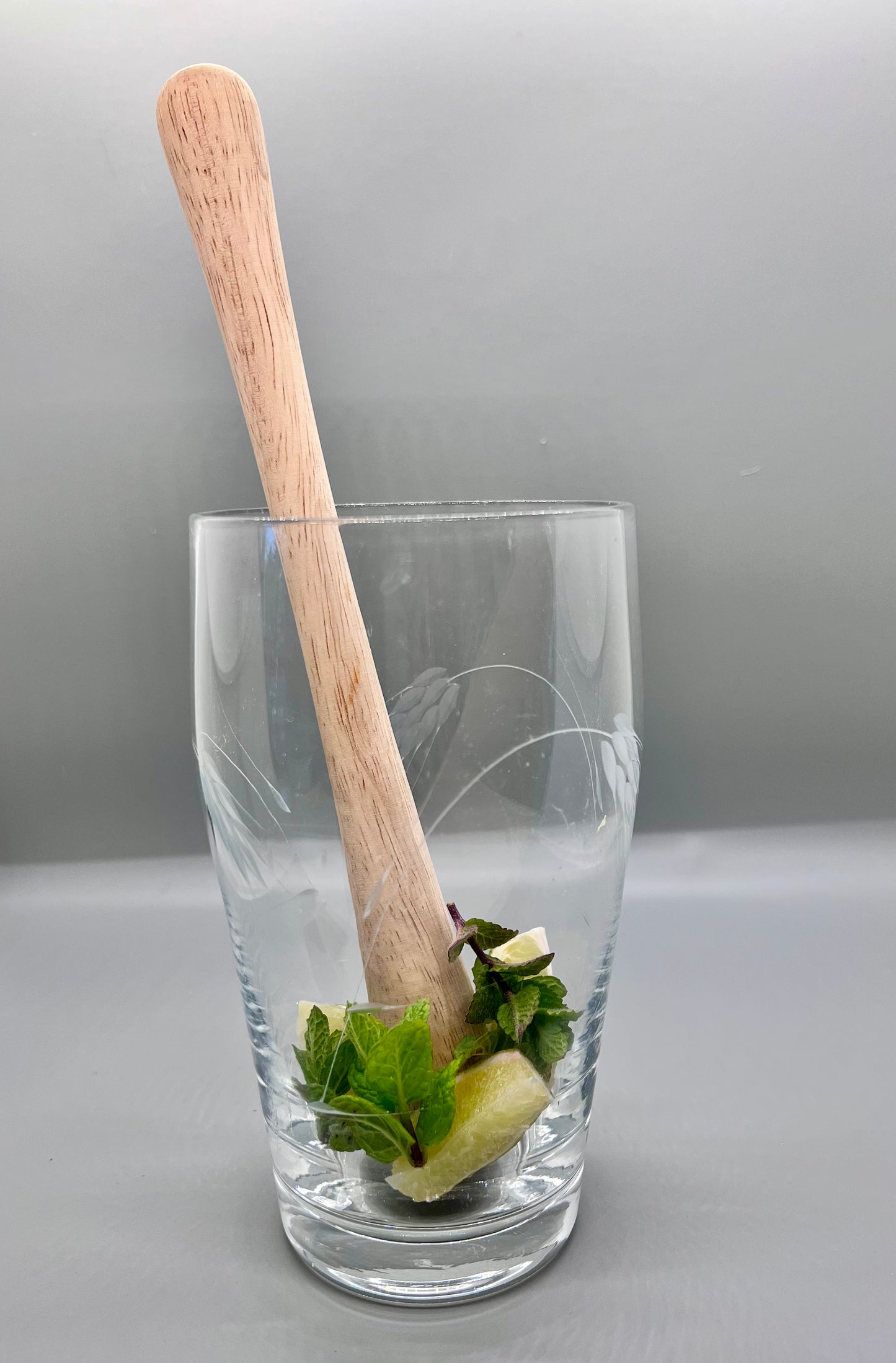 9.75 inch wood muddler in mixing glass with mint and limes